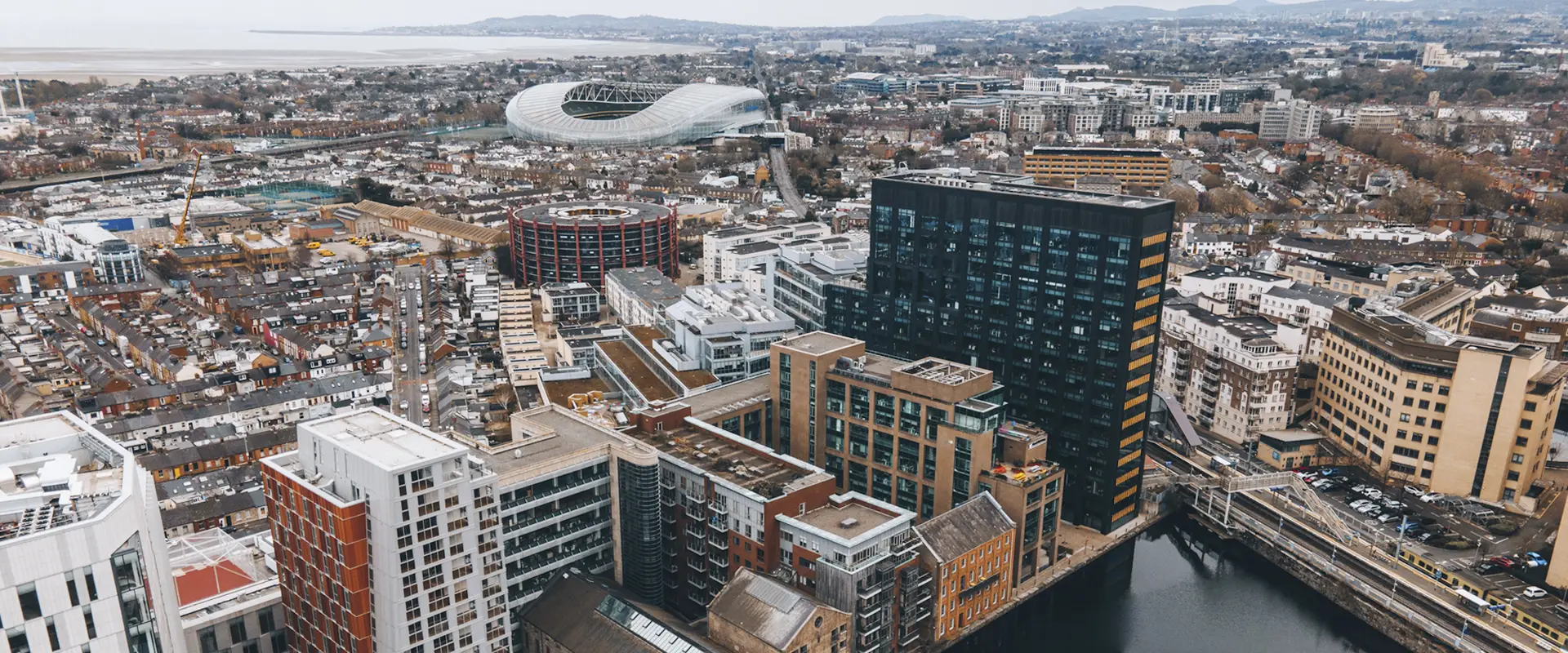 Aerial view of Dublin City skyline featuring a mix of modern office building and traditional residential houses.